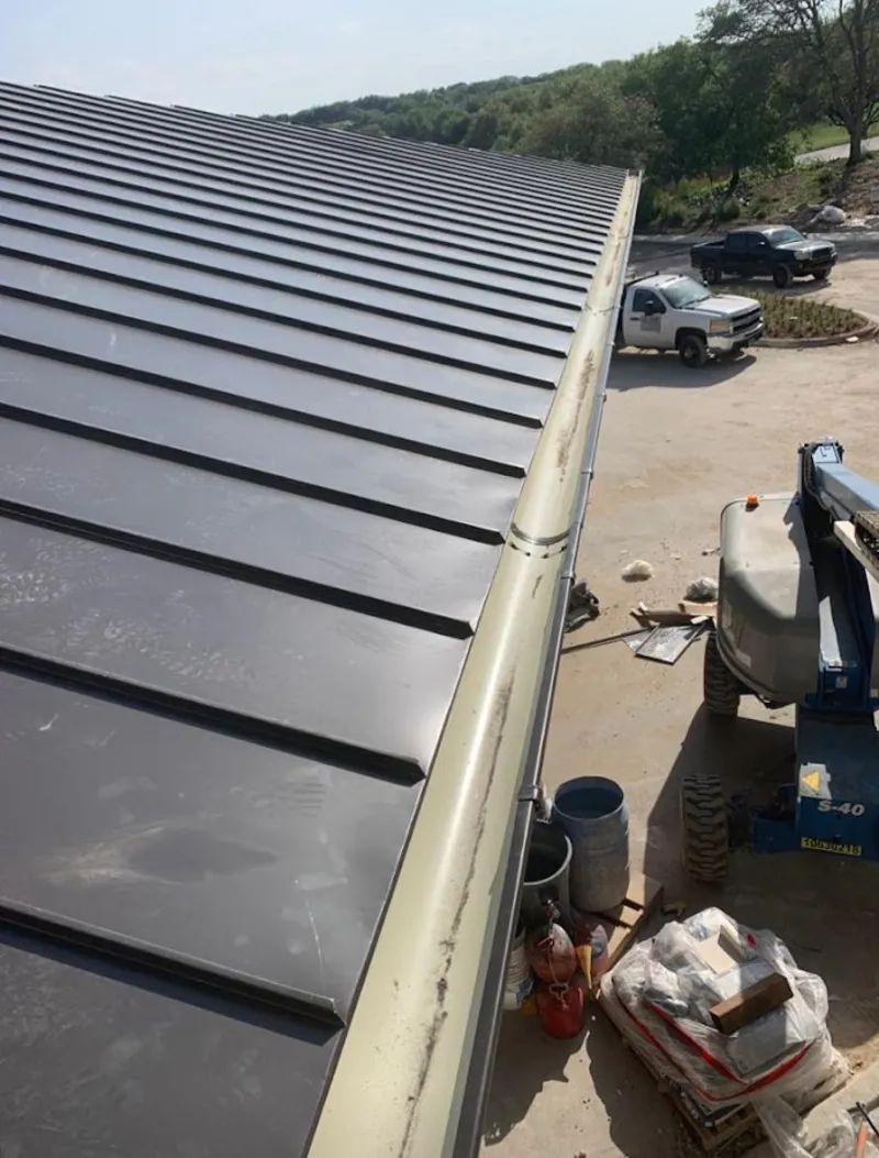 Standing seam panel and gutter detail on a metal roofing jobsite in Gering